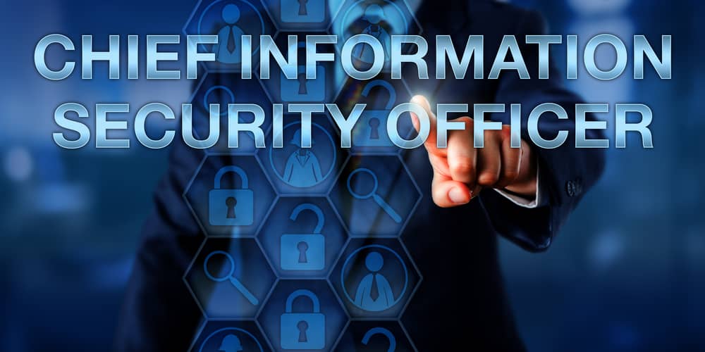 Una mano selecciona digitalmente las palabras "CHIEF INFORMATION SECURITY OFFICER" en una pantalla, rodeada de iconos de seguridad.