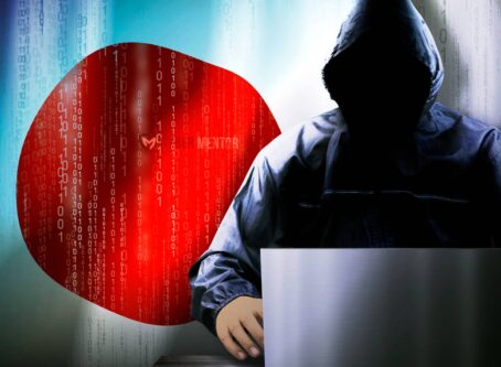 Imagen de una persona encapuchada sentada frente a un ordenador portátil con un fondo que muestra la bandera de Japón y código binario, ilustrando la preocupación por la vigilancia de las comunicaciones.
