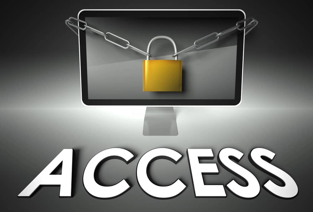 Una representación gráfica de una pantalla de computadora asegurada con un candado y una cadena, con la palabra "ACCESS" (Acceso) en primer plano.