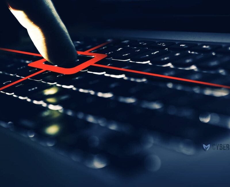 Un dedo presiona una tecla de teclado resaltada en rojo con líneas que se extienden, sugiriendo una acción sin interacción previa, sobre un fondo oscuro.