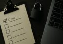 Checklist de seguridad informática con un candado y un portátil sobre un escritorio.