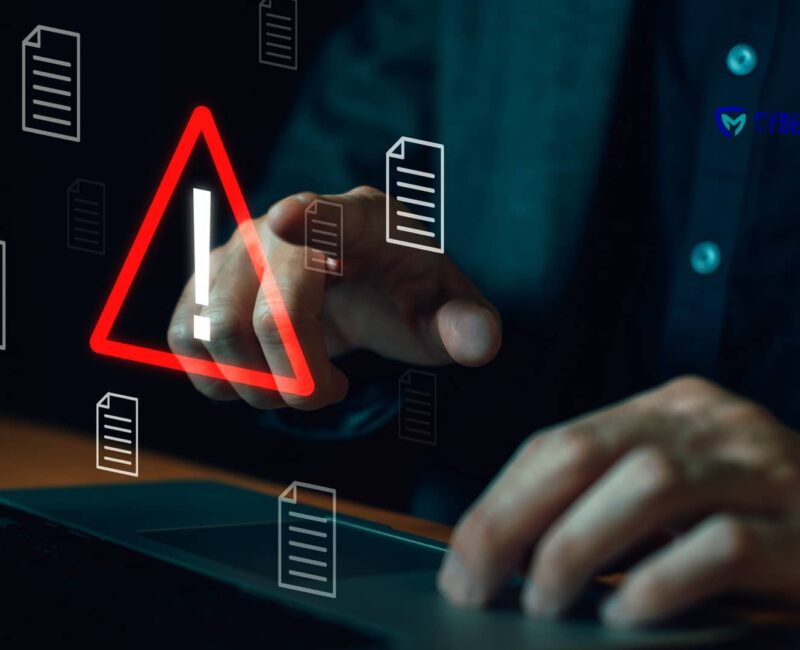 Persona frente a un portátil interactuando con un icono de advertencia que simboliza un archivo adjunto peligroso.